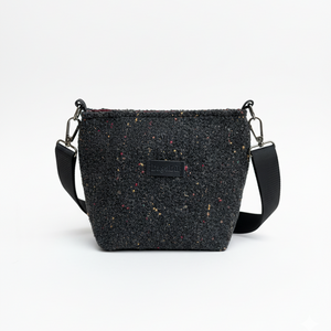 Black textured crossbody bag on a white background