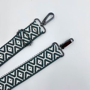 Two adjustable shoulder straps with a geometric pattern, primarily in gray and white, lying flat against a white background.