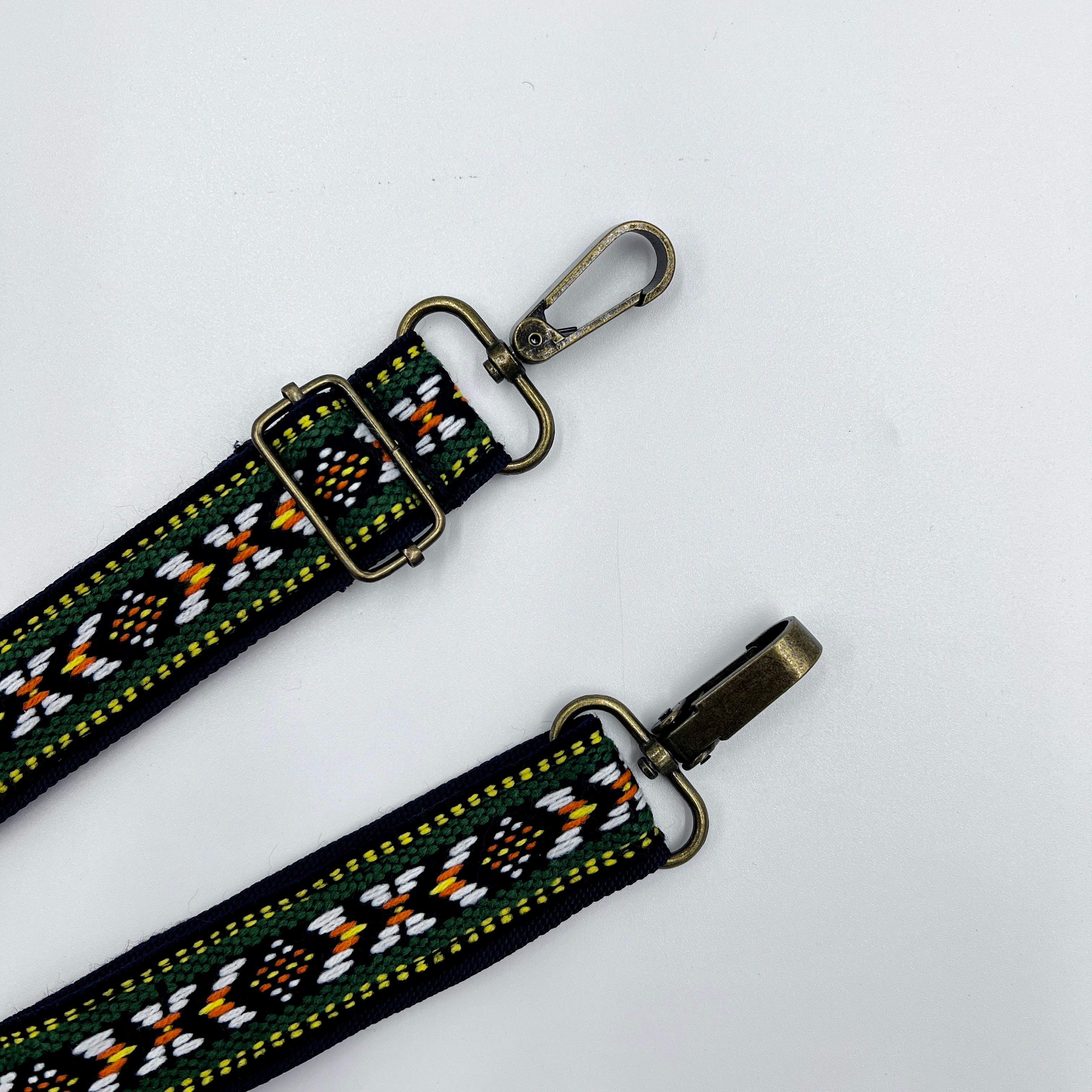 Adjustable Folk Shoulder Strap with a colorful geometric pattern and metal buckle, laid out on a white background.