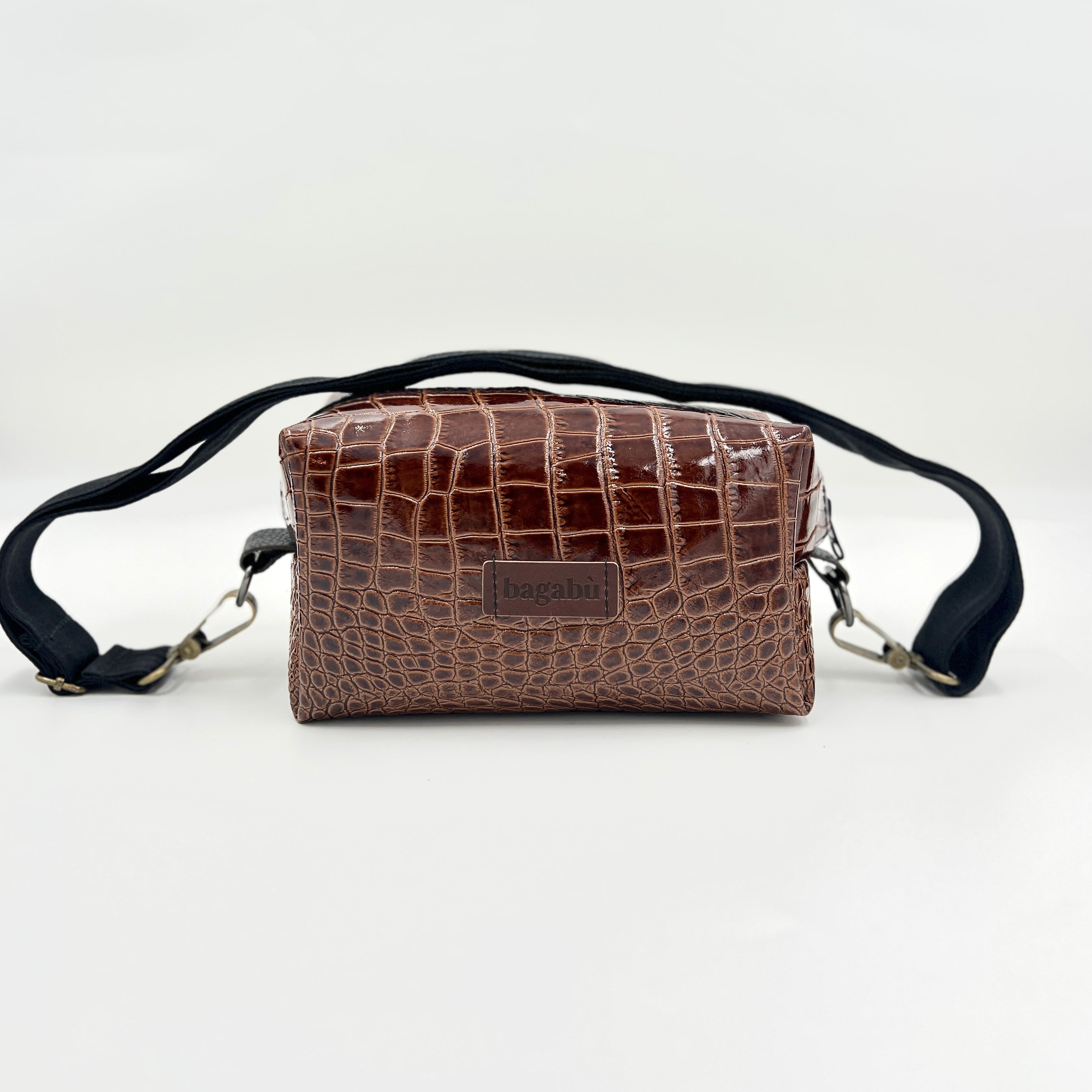 A brown leather shoulder bag with a textured pattern, featuring a black strap and a brand label on the front.
