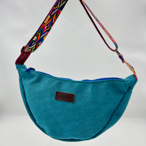 Blue bag with a colorful strap on a neutral background