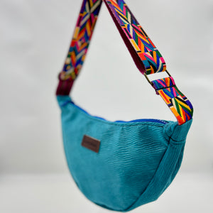 Blue bag with colorful strap on a neutral background