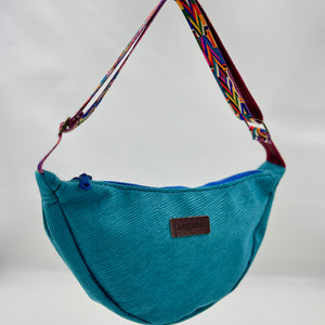 Blue bag with a colorful strap on a neutral background