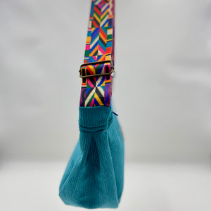 Teal bag with a colorful strap on a white background