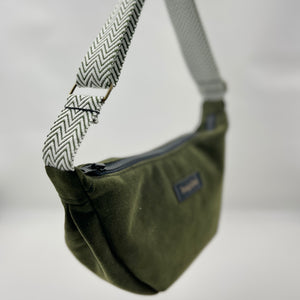 Green shoulder bag with patterned strap on a neutral background