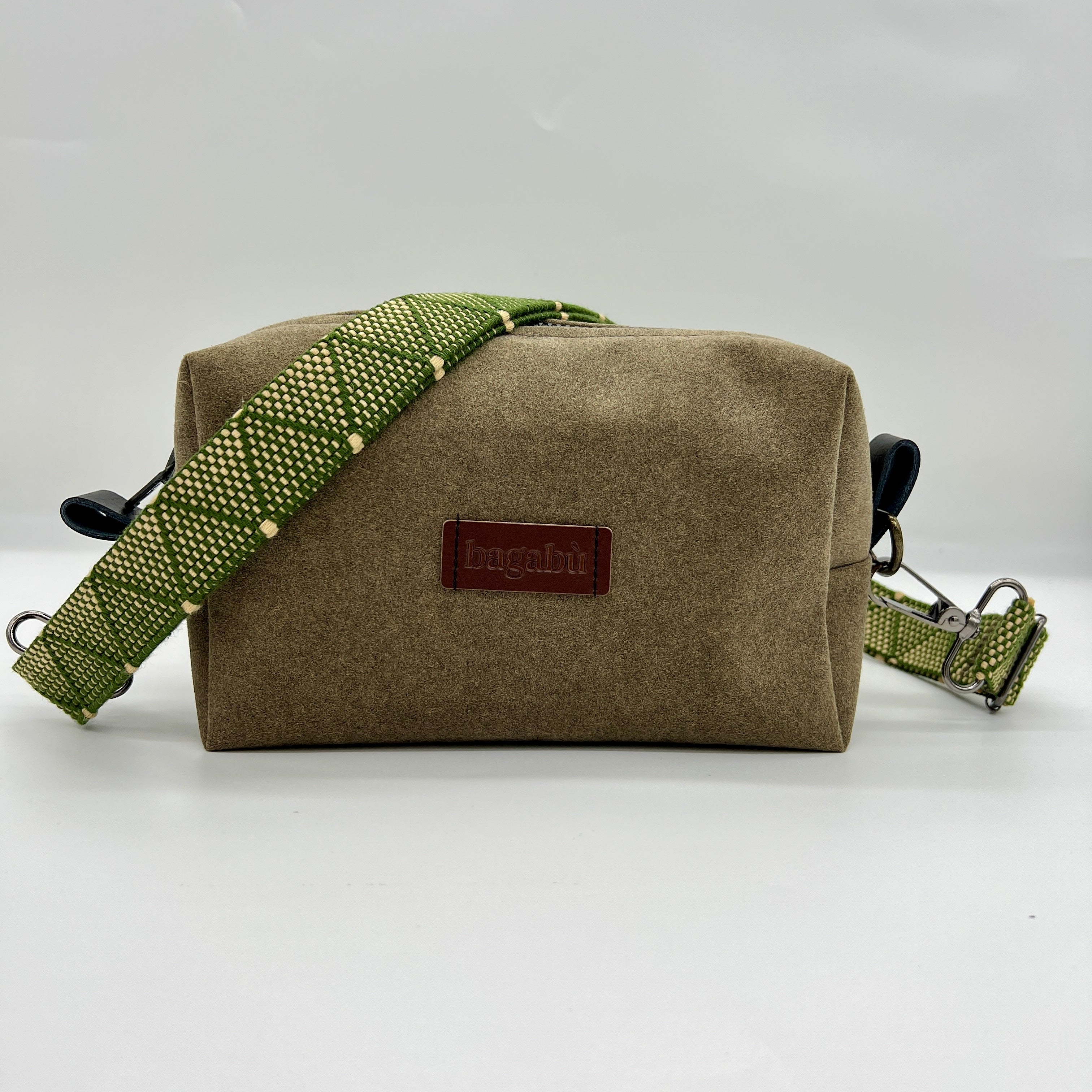 A green shoulder bag with a black strap and a beige body, displayed against a white background.