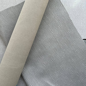 Close-up of textured gray and beige fabric on a light gray background