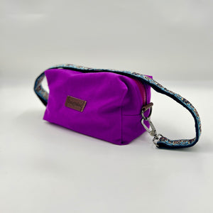 Purple pouch with a floral strap on a light gray background