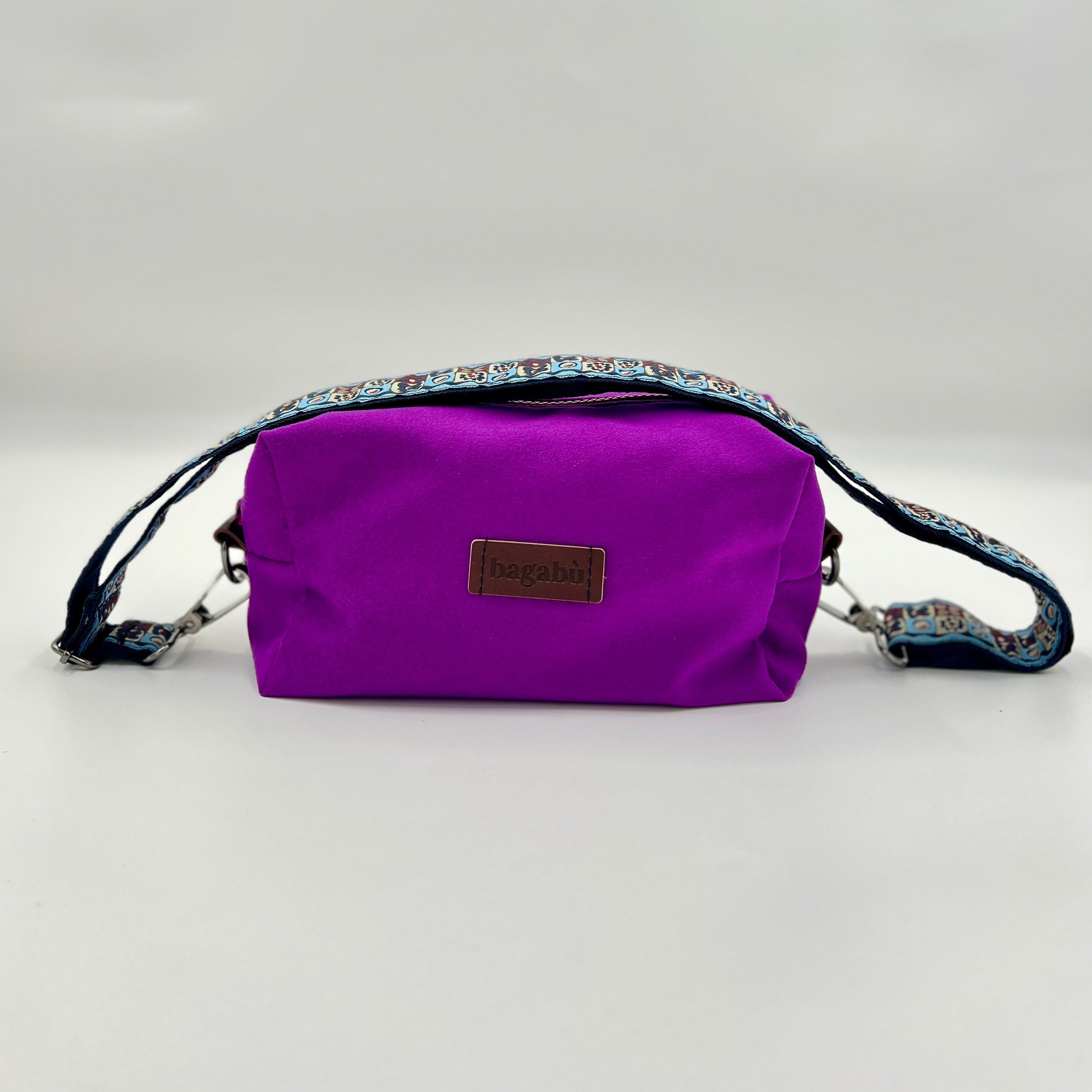 Purple bag with a floral strap on a light gray background