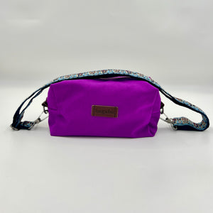 Purple bag with a floral strap on a light gray background