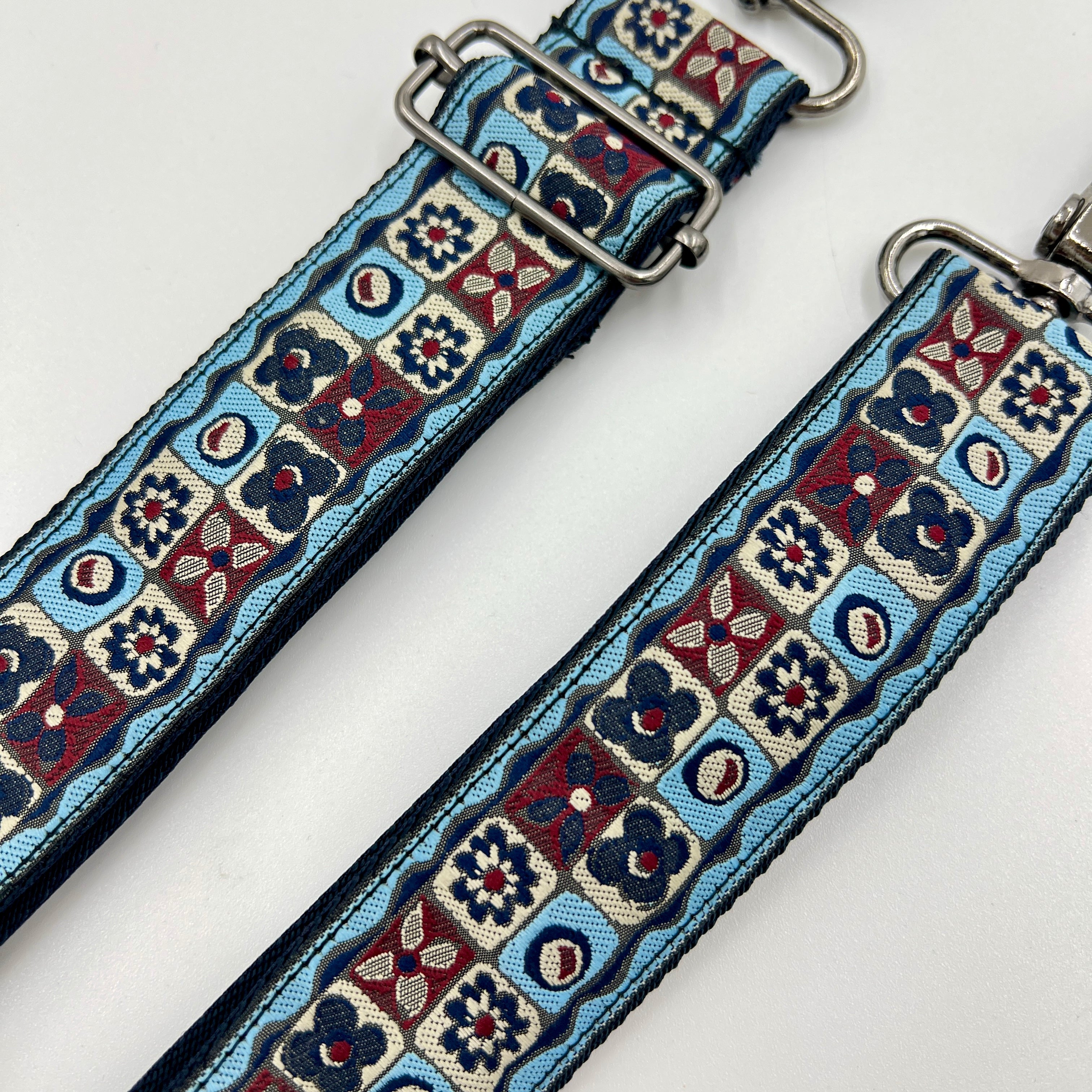 Two patterned straps with metal buckles on a white background