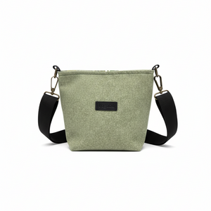 Green crossbody bag with black strap on a white background