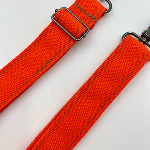Orange strap with metal buckle on a white background