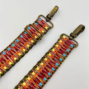 Colorful beaded strap with metal clasps on a light gray background