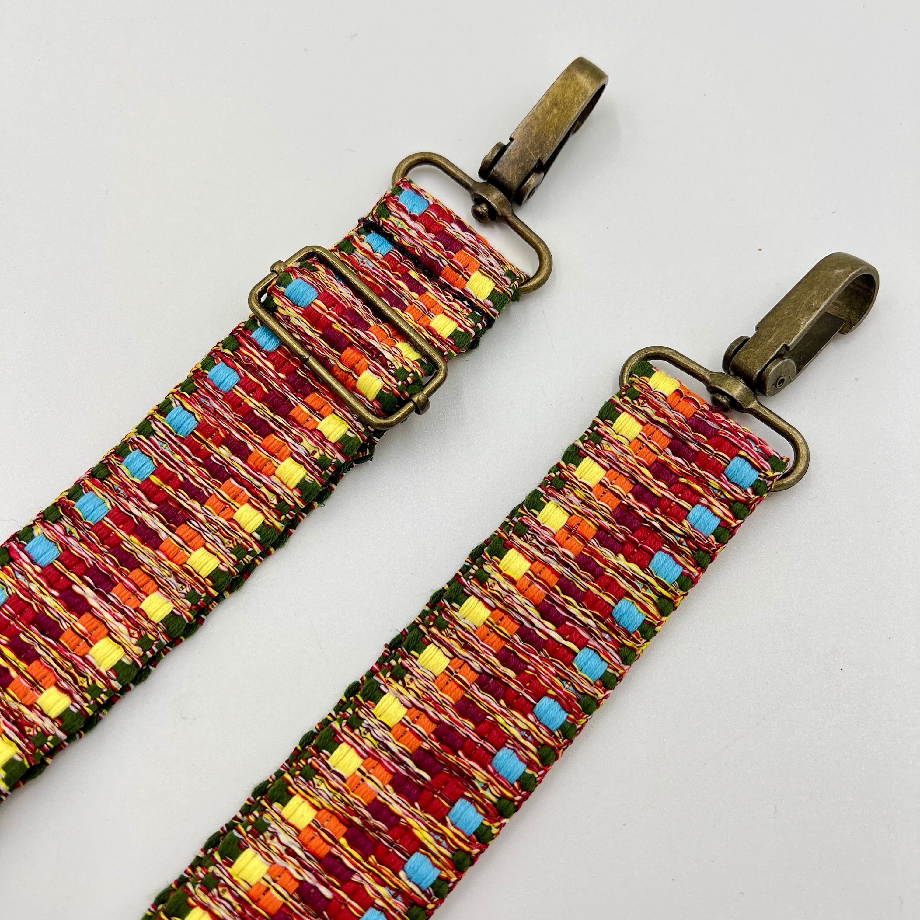 Colorful beaded strap with metal clasps on a light gray background