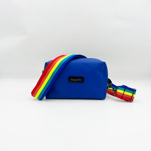A blue leather shoulder bag with a multicolored striped strap, displayed against a white background.