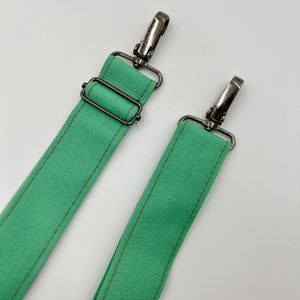Green strap with metal hardware on a white background