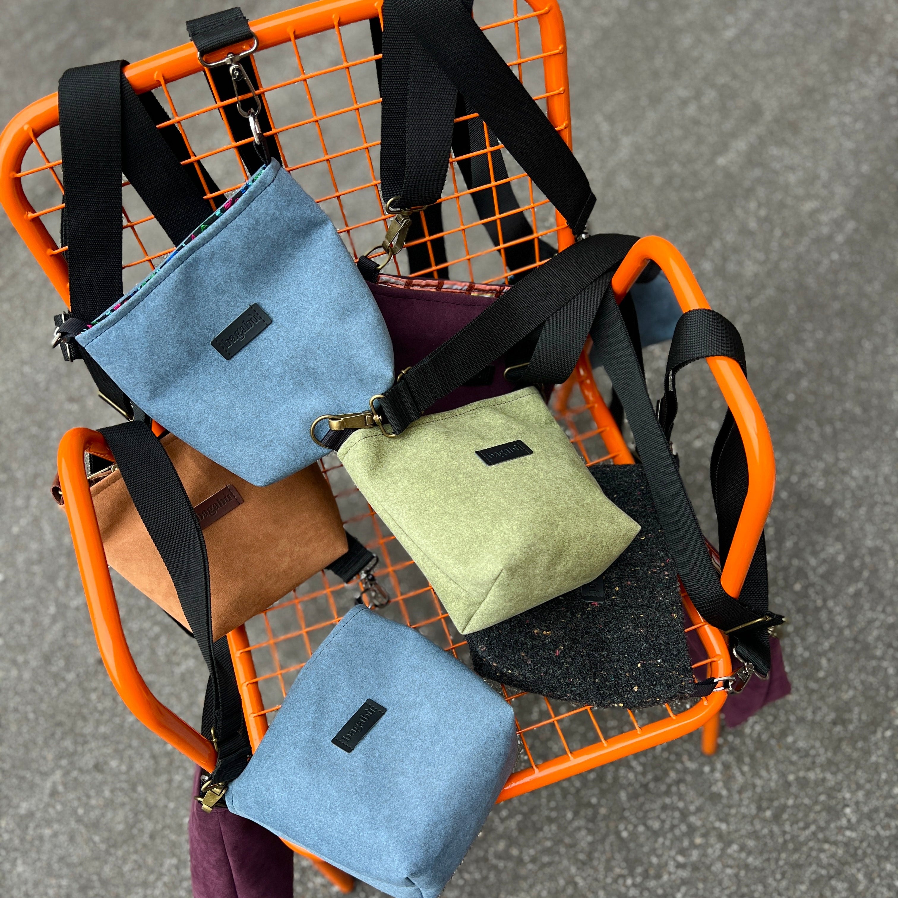 Orange metal cart with multiple bags on a gray pavement background