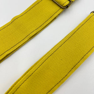 Two yellow straps with a metal buckle on a white background