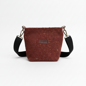Brown crossbody bag with black straps on a white background