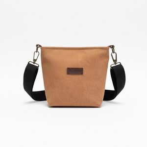 Tan crossbody bag with black strap on a white background