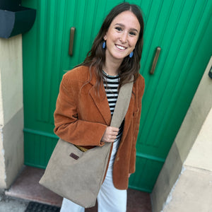 Woman in a brown coat standing in front of a green door