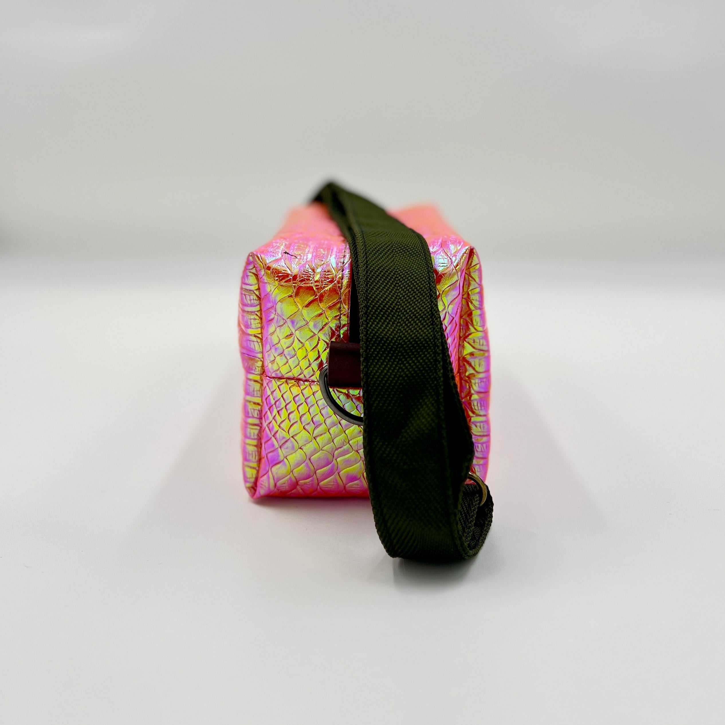Pink and yellow patterned pouch with a black strap on a white background