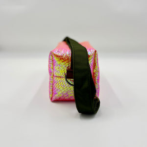 Pink and yellow patterned pouch with a black strap on a white background