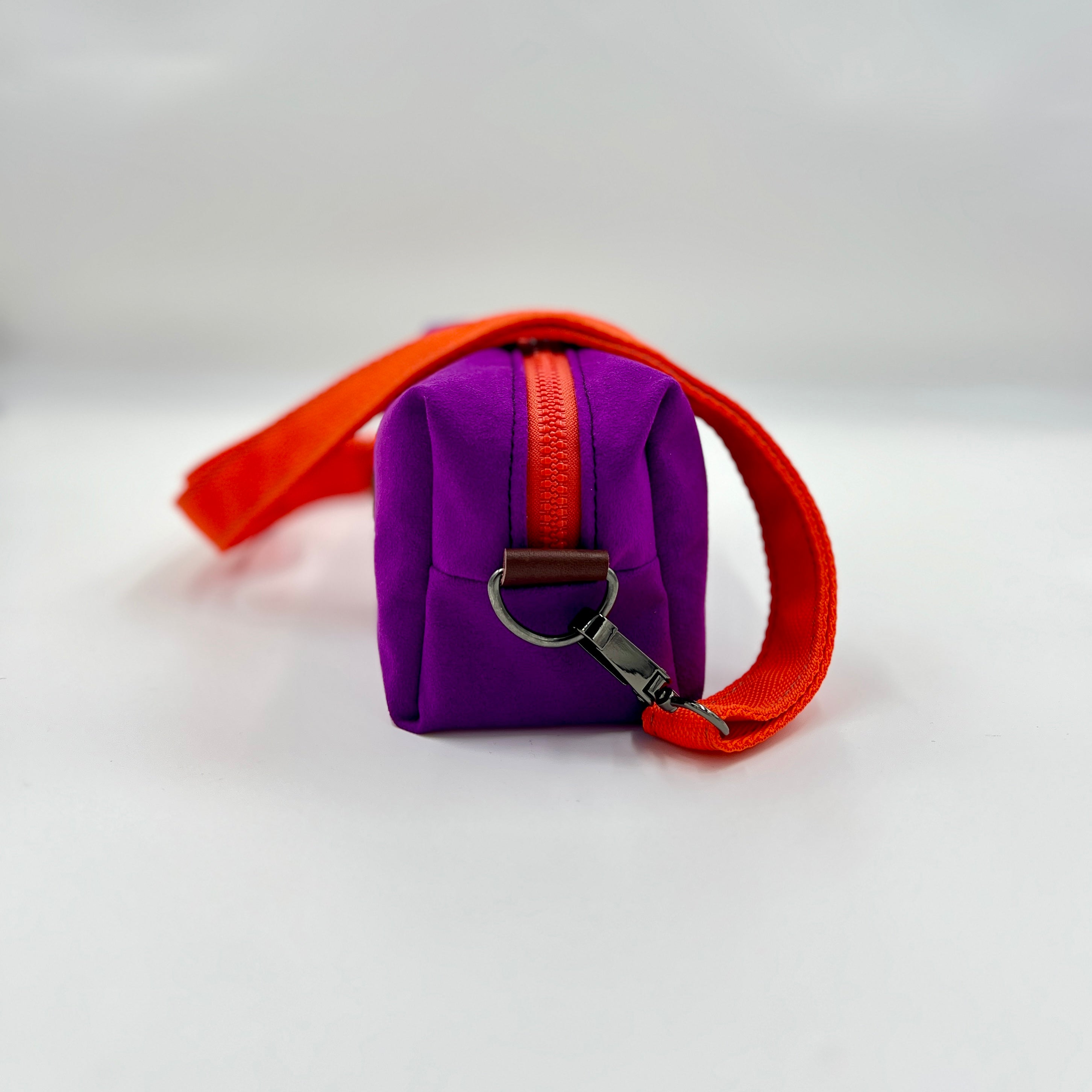 Purple bag with an orange strap on a white background