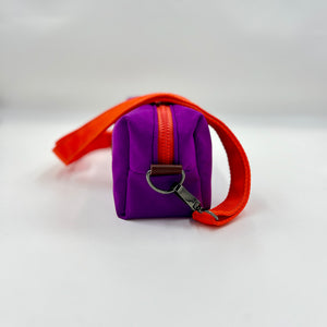 Purple bag with an orange strap on a white background