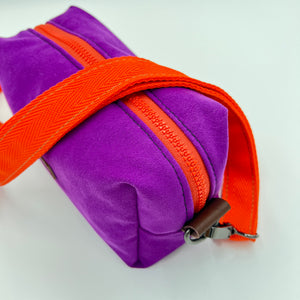 Purple bag with an orange strap on a white background