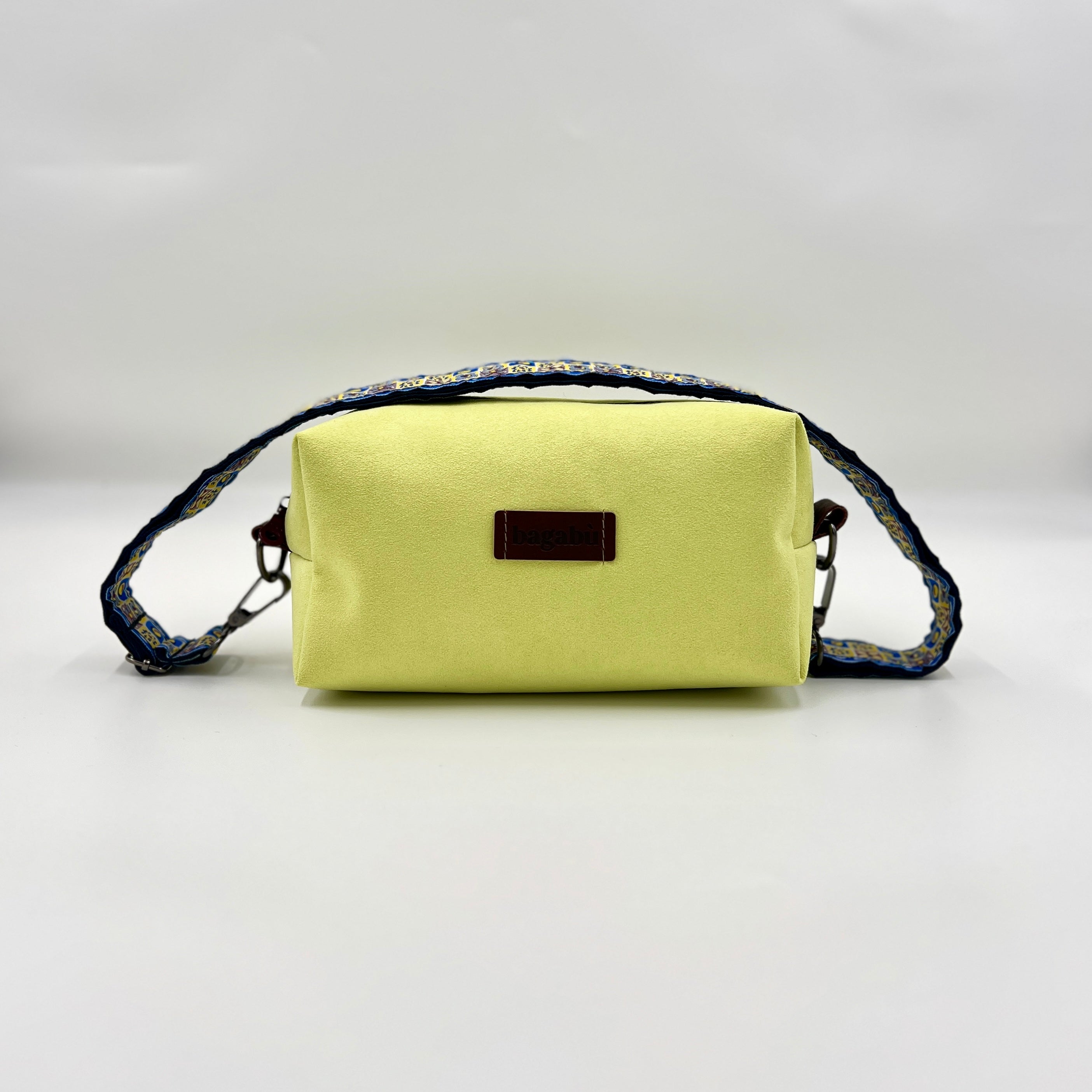 Light green handbag with a dark strap on a light gray background