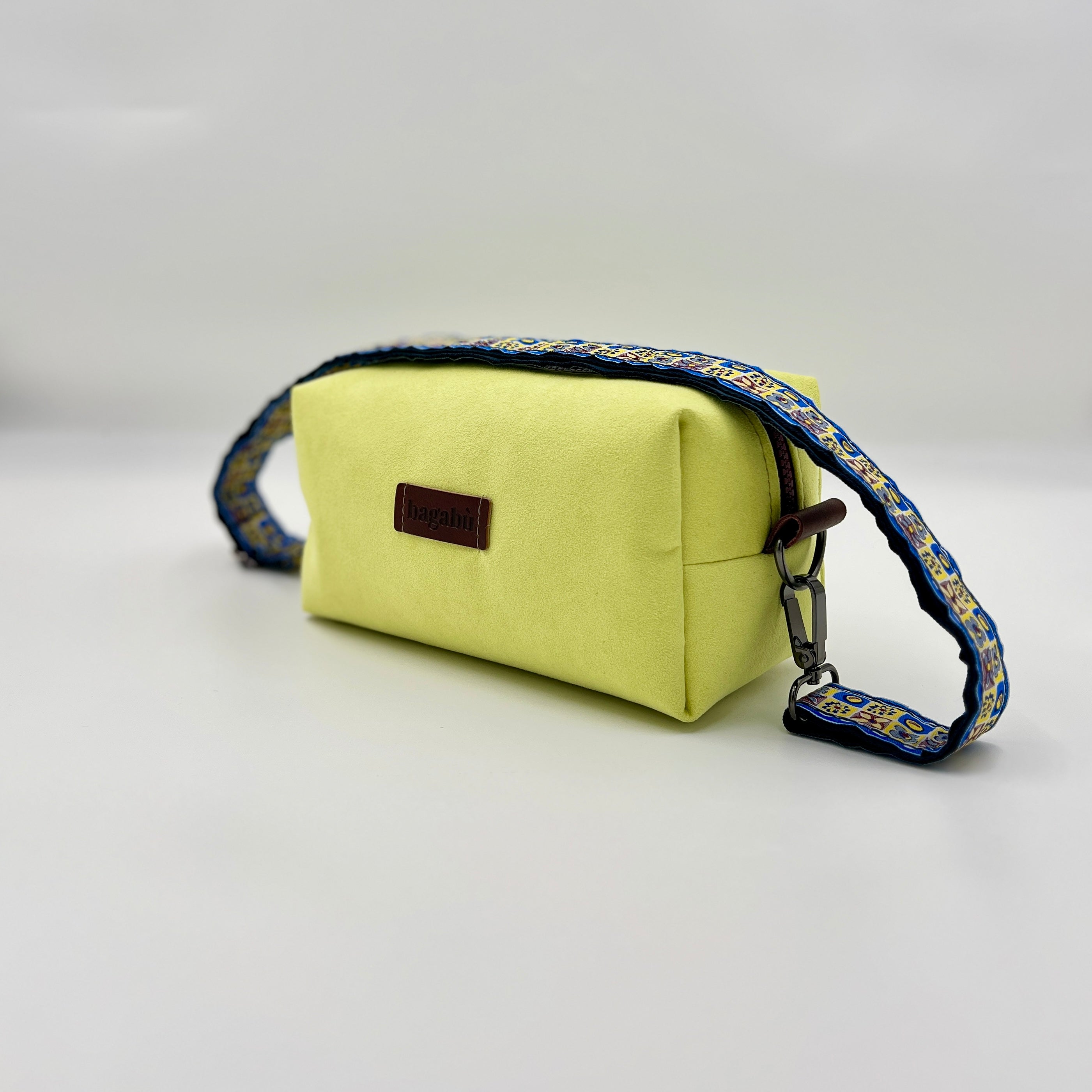 Yellow pouch with a blue strap on a light gray background