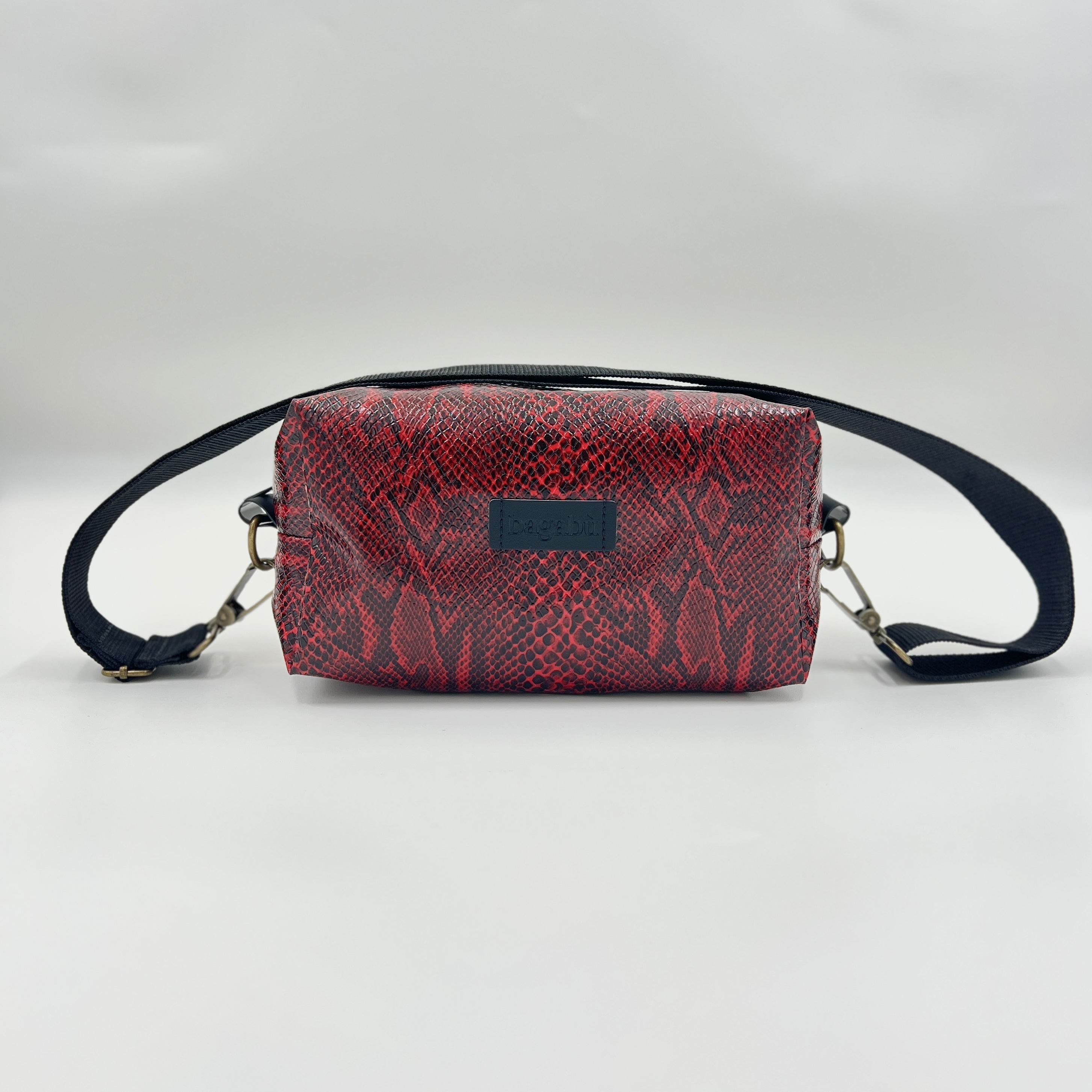 Red snake print bag with black strap on a light gray background