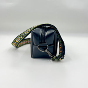 Black square pouch with decorative strap on a white background