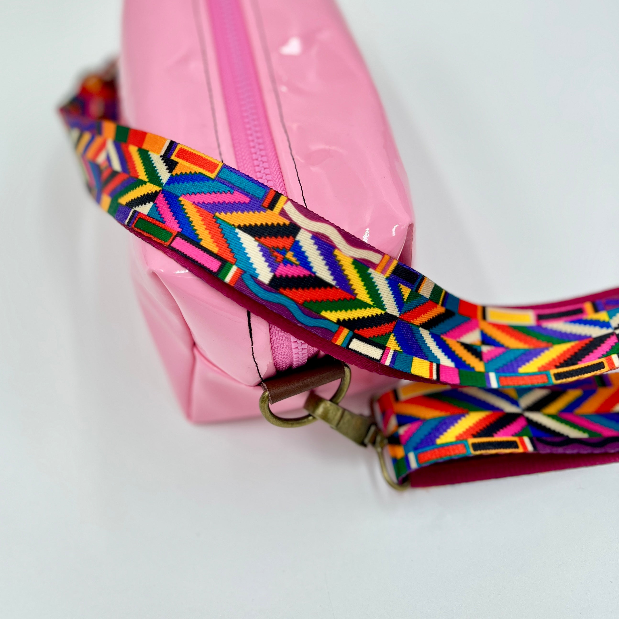Pink bag with a colorful strap on a white background