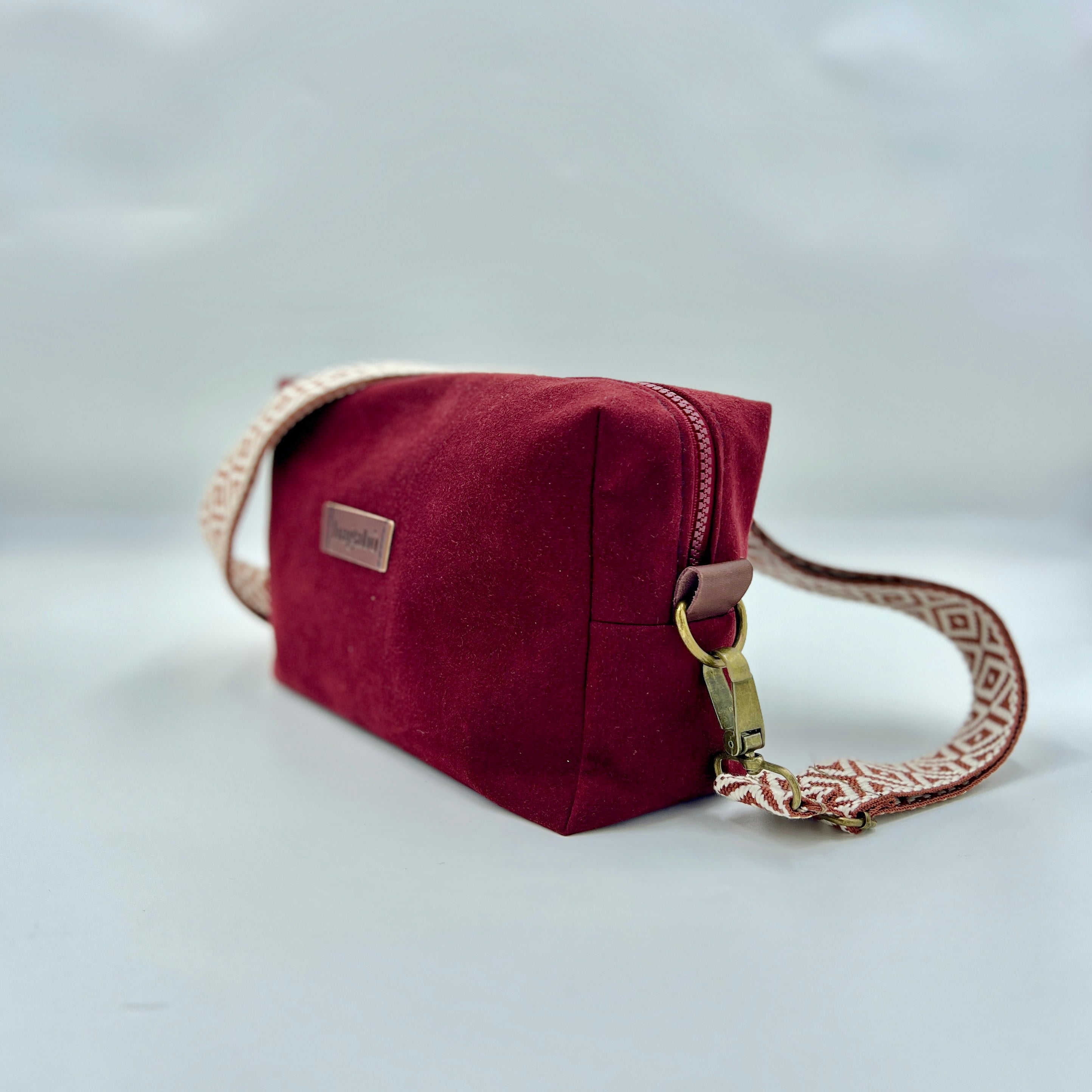 Red handbag with a strap on a light gray background
