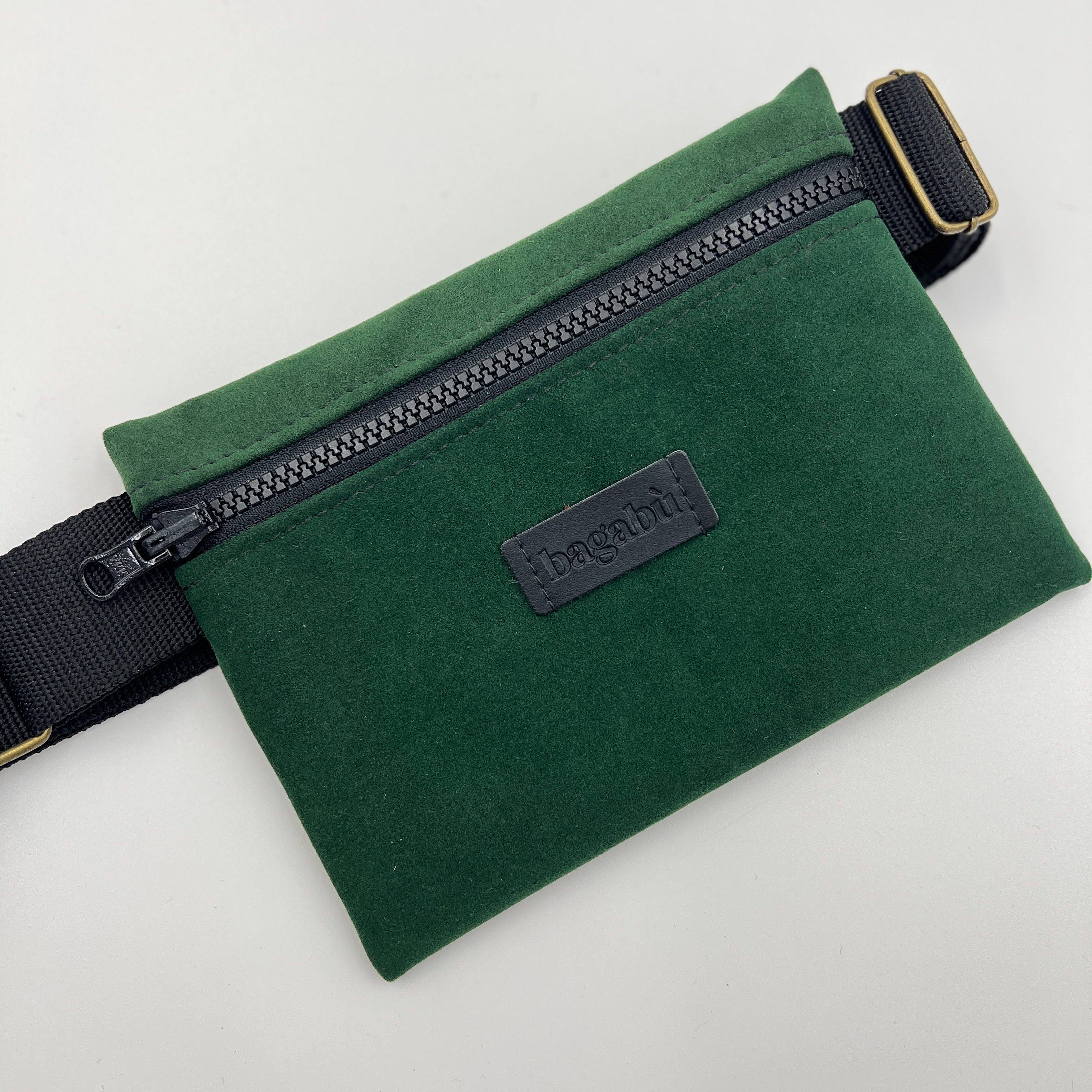 Green waist bag with a visible brand label on a light gray background