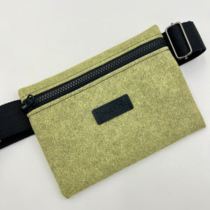Green waist bag with black zipper and strap on a white background