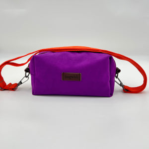 Purple bag with orange strap on a light gray background
